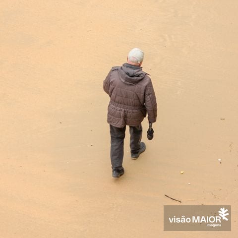 Um homem a caminhar na praia