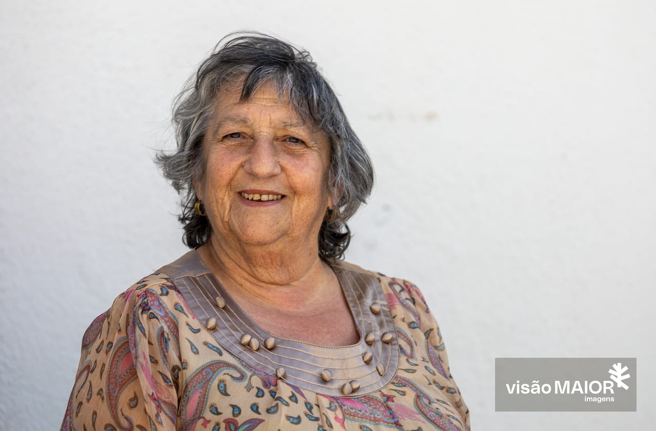 Mulher de frente para a câmara com cabelo grisalho a sorrir
