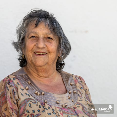 Mulher de frente para a câmara com cabelo grisalho a sorrir